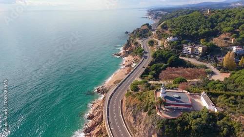 Drone flying over calella de mar lighthouse and coastal road