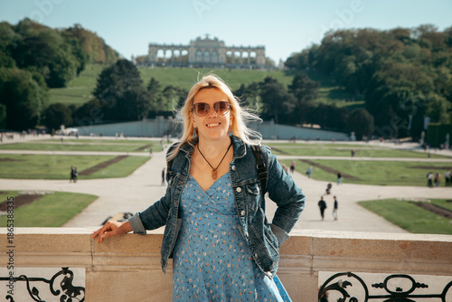 Canvas Print Summer travel portrait of a young blonde woman standing in front of Schönbrunn Palace in Vienna, Austria