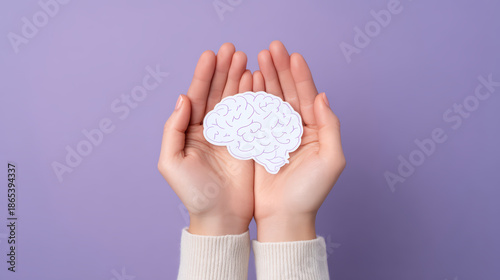 Brain health concept with hands holding paper cutout brain on purple background, symbolizing mental care and cognitive support with gentle touch and minimal style