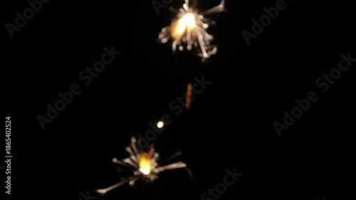Glowing sparklers isolated on black background. Handheld sparklers burning in the dark. Glowing sparklers on black background.