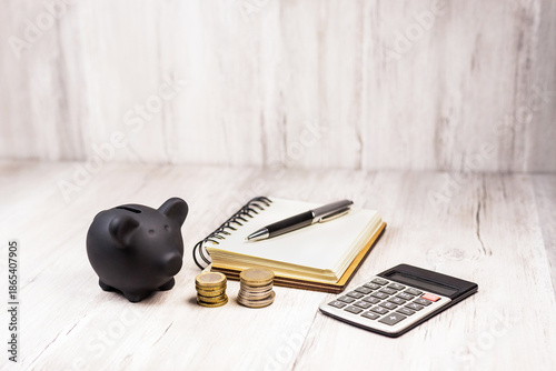 Financial planning tools with calculator, notebook, pen and coins on light wooden background. 
