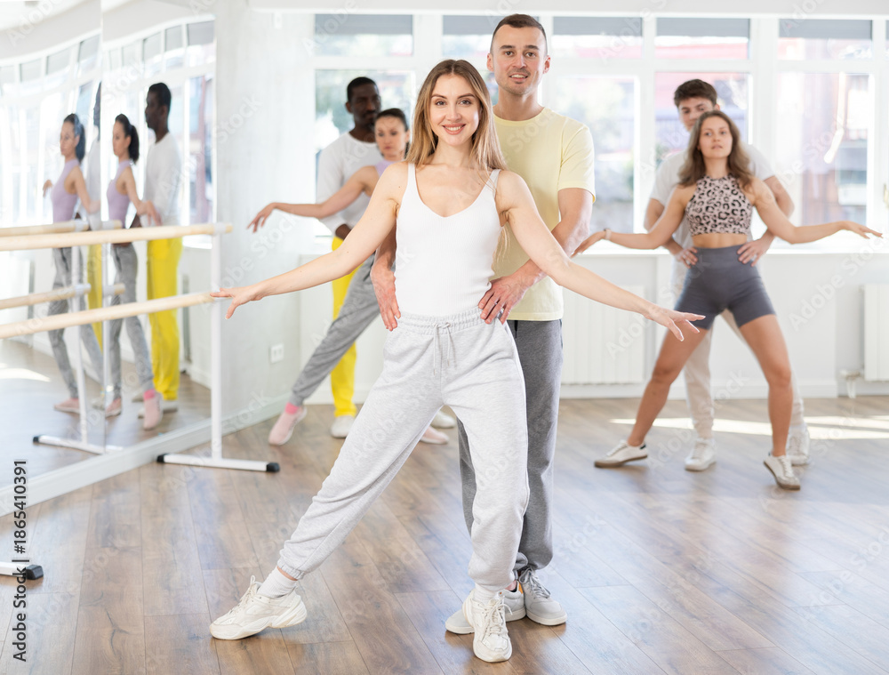 Fototapeta premium Energy guy and young woman are dancing classic version of waltz in couple during lesson at studio. Leisure activities and physical activity for positive people.