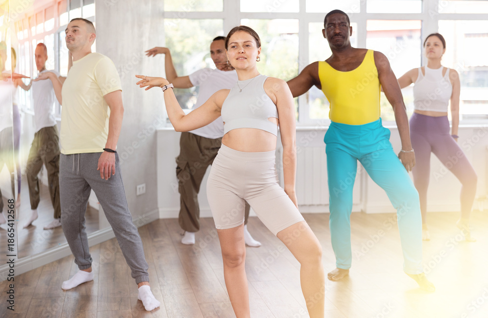 Naklejka premium Active young woman practicing jazz-funk dance in training hall during dancing classes