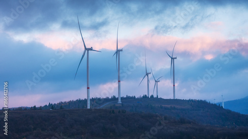 Wallpaper Mural Silhouettes of wind turbines on hike in blue hour in the morning with cloudy sky Torontodigital.ca