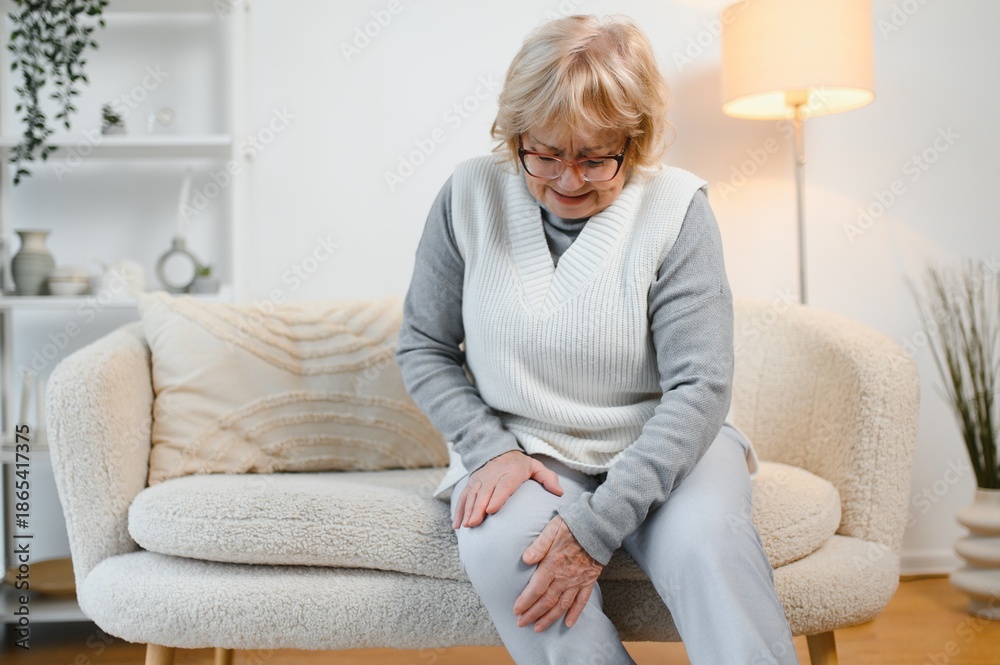Obraz premium Arthritis symptoms. Woman suffering from pain in knee at home