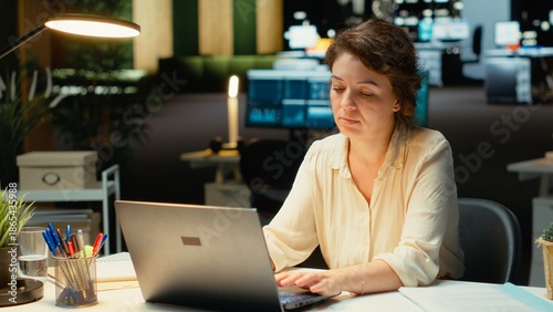 Foto Discouraged woman creating plans and documenting objectives to share with executives during next morning meeting