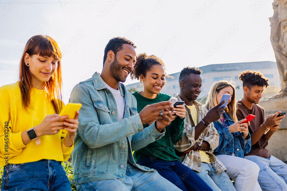 © Xavier Lorenzo - Happy young multiracial group of teenage friends using mobile phones outdoors. Addicted gen z people chatting on cellphone and watching social media content on app © Xavier Lorenzo - Happy young multiracial group of teenage friends using mobile phones outdoors. Addicted gen z people chatting on cellphone and watching social media content on app