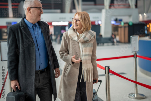 Cuadro en lienzo Mature couple walking and talking in airport