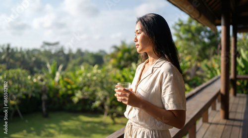 Serene Asian Woman in Linen Outfit Enjoying Morning View on Tropical Villa Balcony