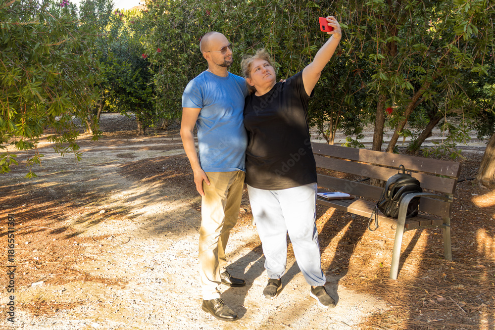 Obraz premium Couple taking selfie with mobile phone in park