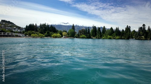 Turquoise lake with forested shoreline and mountain backdrop