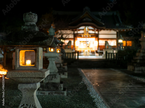 ロウソクの火が灯された石灯籠