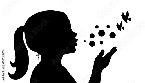 Silhouette of girl blowing bubbles with birds flying away freely