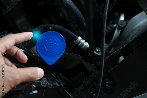 windshield washer fluid in a car, highlighting the washer reservoir, blue cap, and essential maintenance process for safe, clean, and reliable driving.