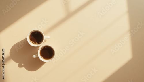 Two romantic coffee cups in warm morning light on beige background with shadows, perfect with love