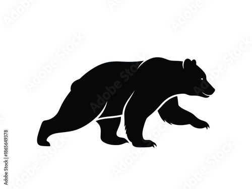 Black silhouette of a bear walking on a in a side view