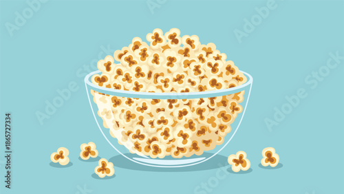 Large glass bowl filled to the brim with buttery salted popcorn, with extra kernels scattered around on a calm blue background.