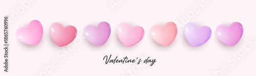 Valentine’s Day background with row of glossy pink and red heart shapes on white backdrop, romantic love concept for couples, wedding, anniversary, greeting card, banner, celebration and sweet.