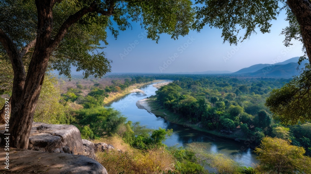 Fototapeta premium Serene River Landscape Surrounded by Lush Green Forests Under Clear Blue Sky in Nature's Tranquility