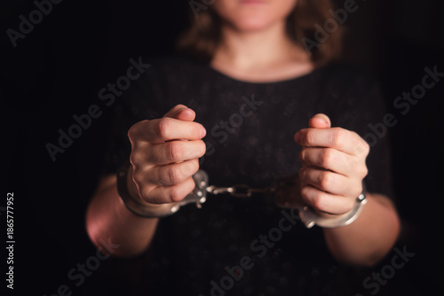 Photography Woman in dark clothes with hands handcuffed