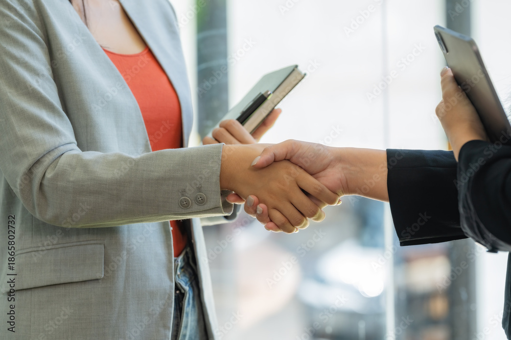 Naklejka premium Business people shaking hands in an office.