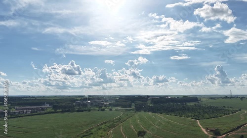 A timelapse video of a serene landscape with a vast green field under a blue sky with clouds