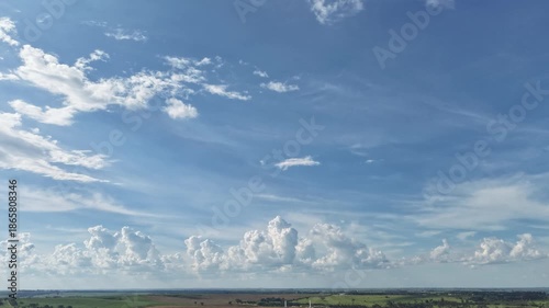 A timelapse video of a serene blue sky with white clouds over a landscape