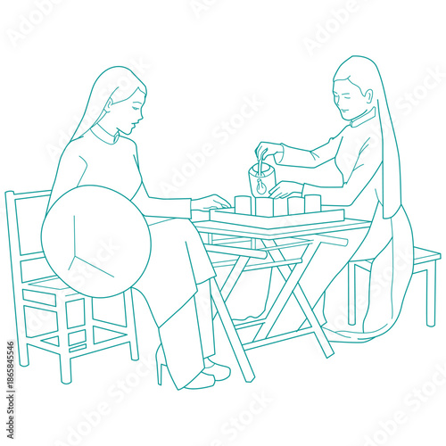 Two women wearing traditional Ao dai preparing tea during the Vietnamese Lunar New Year Tet