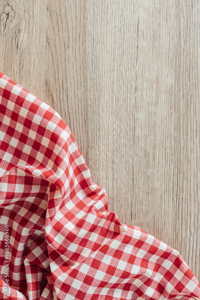 Obraz premium Red and White Checkered Tablecloth on Wooden Surface Background