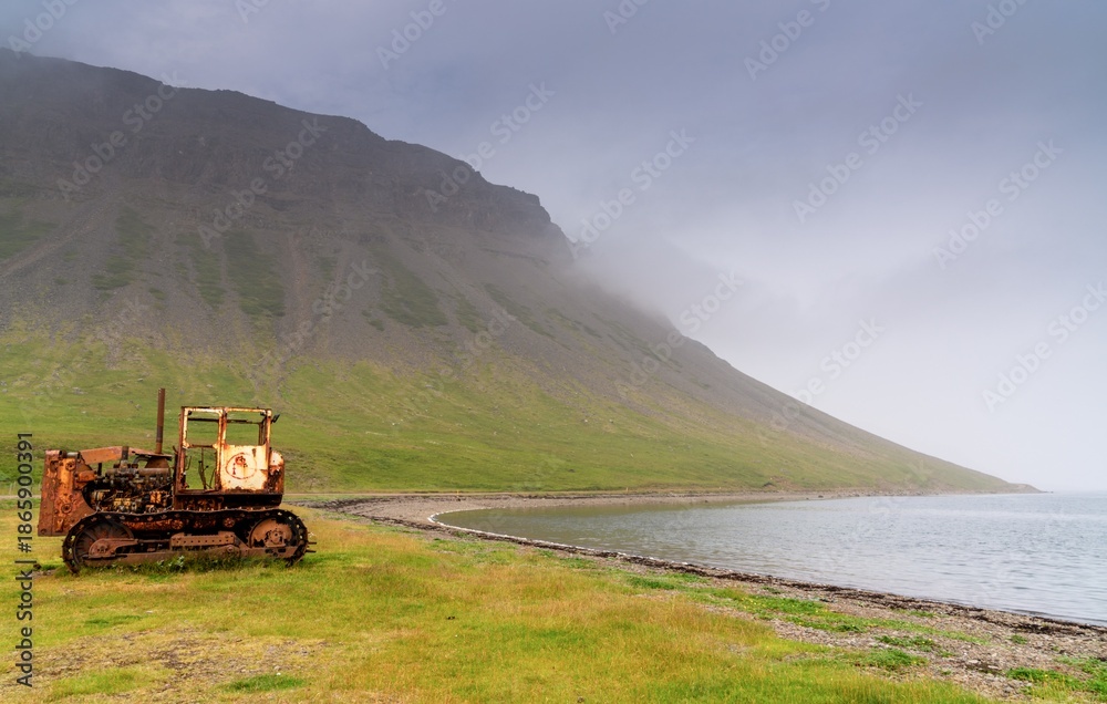 Fototapeta premium old rusty caterpillar on the shores of the Westfjords in northwest Icleand near the village of Fossfjordur