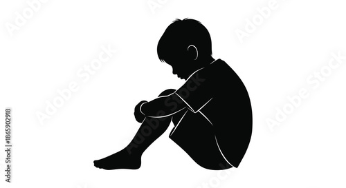 a solitary child sits with knees drawn up to their chest in a dark silhouette