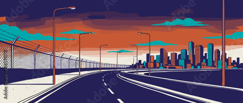 Empty urban highway with a fence and streetlights curves towards a modern city skyline under a dramatic orange and blue sunset sky