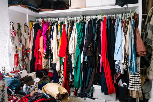 Messy home closet full of various clothes and accessories