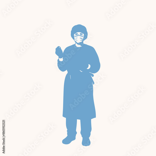 Medical professional wearing blue protective gown and face mask standing with arms crossed