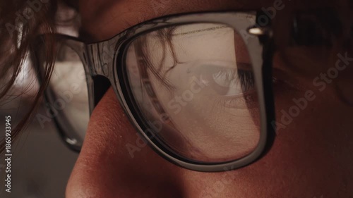 Teenager in glasses on the lenses of which the information on the monitor of the laptop is reflected. Search. Viewing. Internet. Application. Game. Training.