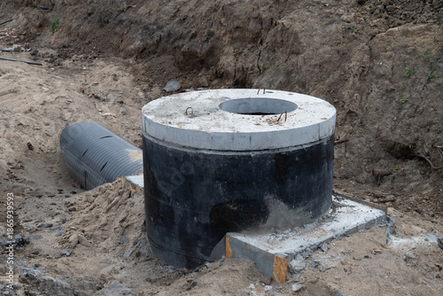 Construction of a concrete septic tank installation site in a residential area during daylight hours