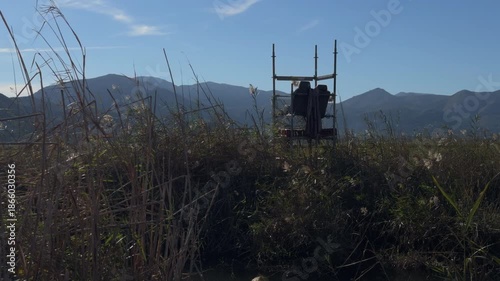 Lonely silhouette in wooden hut over quiet mountain landscape