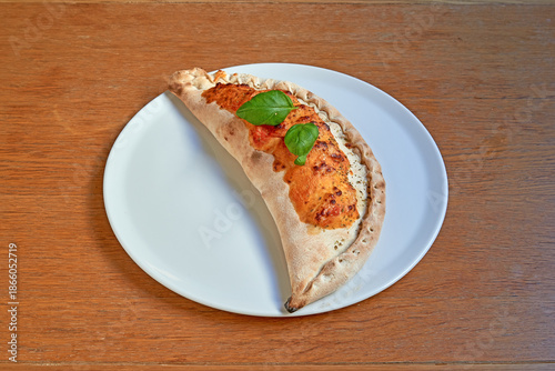 Wallpaper Mural Pizza Calzone on white plat on wooden table Torontodigital.ca