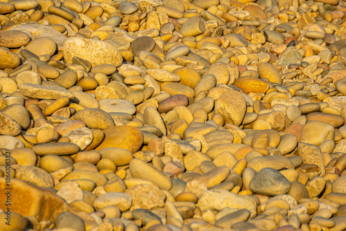 Billede på lærred Pile of smooth golden pebbles highlighting the concept of natural texture