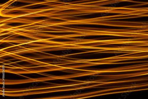 Golden light streaks in motion on black background
