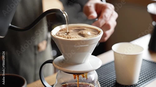 Barista carefully pouring hot water for pour over coffee brewing.