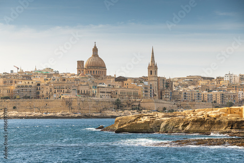Fotografie Scenic panoramic view of the Valletta skyline in Malta across the Mediterranean Sea, featuring the iconic dome of the Basilica of Our Lady of Mount Carmel