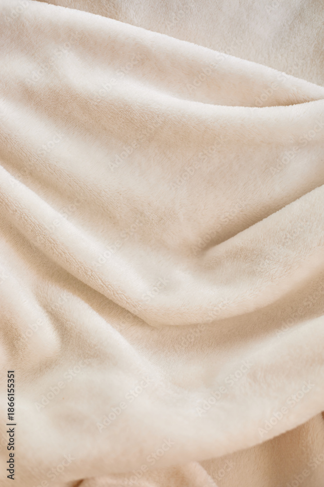 Fototapeta premium Soft beige fabric draped elegantly, showcasing texture and warmth