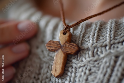 A a hand holding a wooden cross necklace over heart, symbolic moment of.