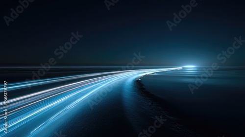 Long exposure photography captures streaks of light as vehicles travel along a curving road at night