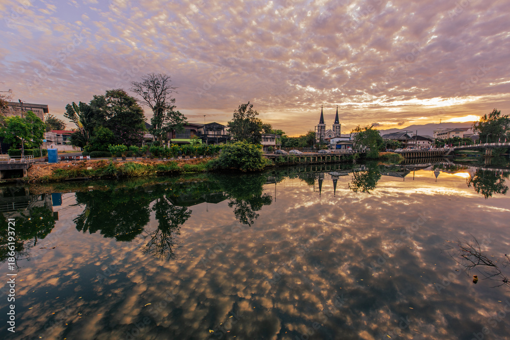 Obraz premium The backdrop of the evening sky along the river, with riverside houses and communities, or tall buildings in the capital city, varies from place to place, but the natural beauty remains unchanged.