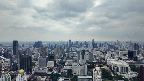 Aerial camera video of dense city skyline under cloudy sky	

