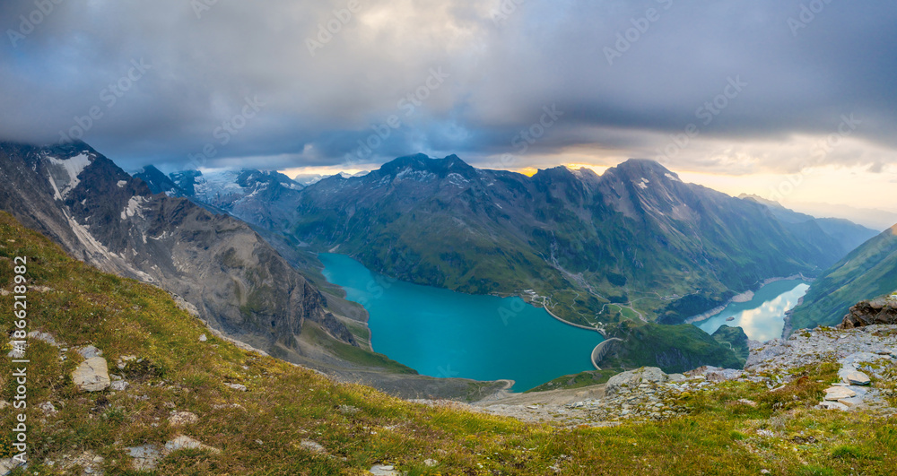 Obraz premium Austria Alps landscape with alpine meadows, forested slopes, and rugged mountain peaks under open sky. High altitude terrain showing natural scenery, geology, outdoor environment, European mountain re