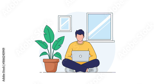 Young man sitting cross legged on the floor while working on a laptop computer in a cozy room with a large plant and bright window.
