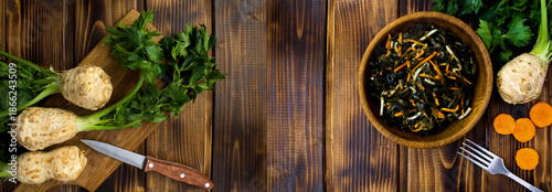 Salad with seaweed, celery and carrots in the brown bowl on a  wooden background. Copy space. Top view.